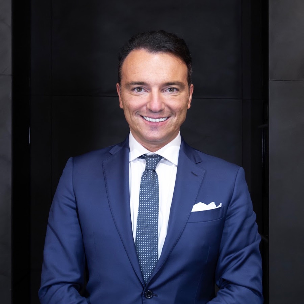 Matteo Rivolta, ritratto in abito blu su fondo scuro