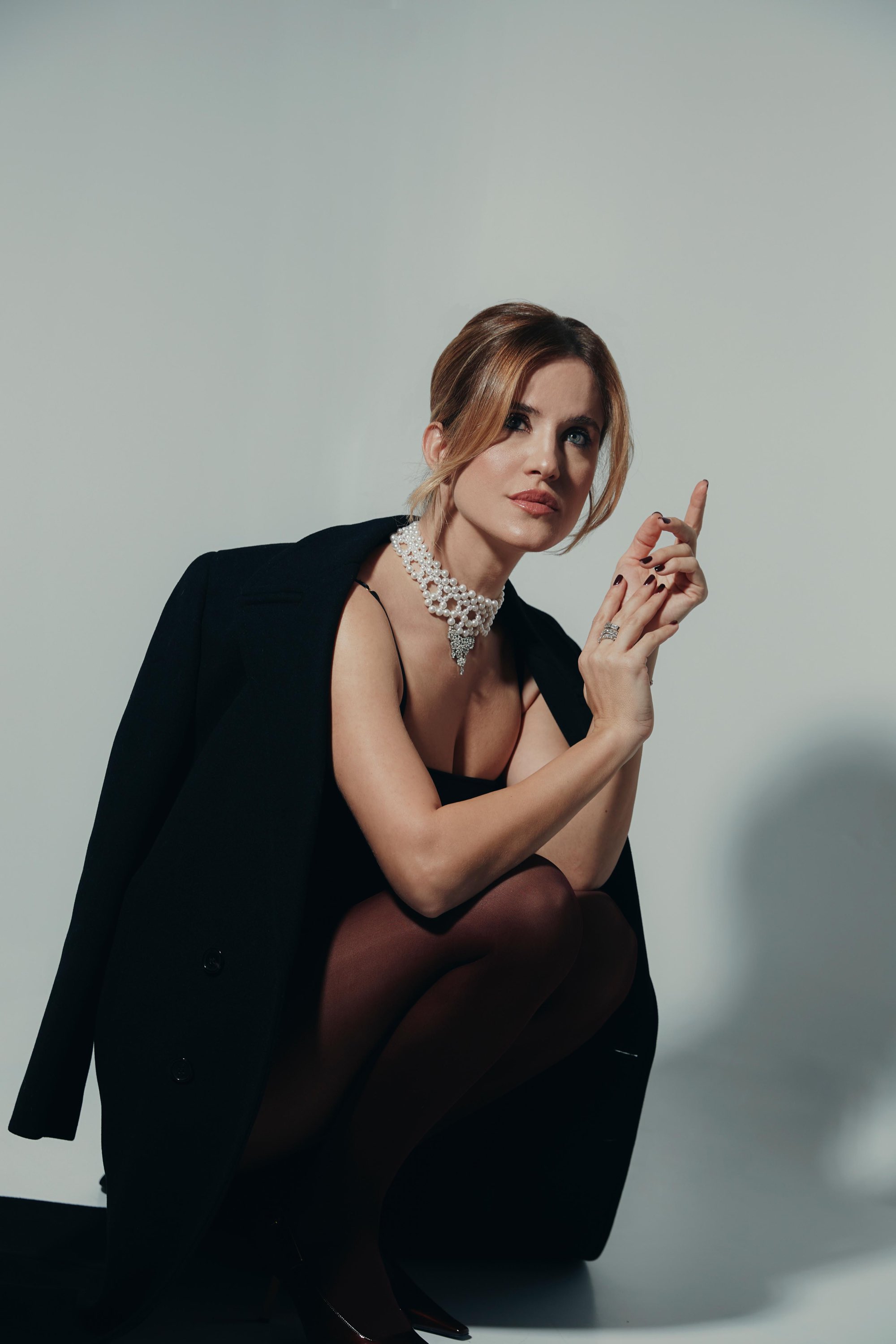 Ritratto in studio di Valentina Morarasu in abito nero con collana di perle